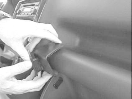 En person monterar en vinklad bygel på en bils interiör.