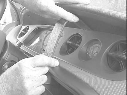 Montering av en bygel i en bilinteriör, nära ventilationsgaller.