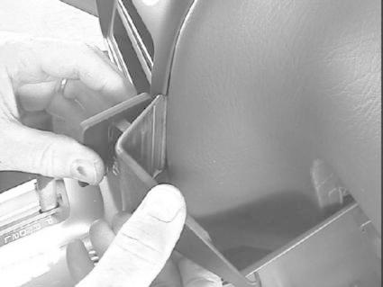 Visar en person som installerar en monteringsbygel i en bil.