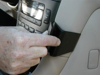 Monteringsbygel i svart plast fästs på bilens inredning.