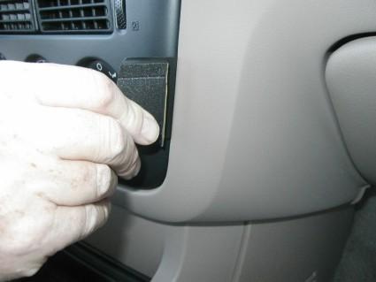 En hand justerar en komponent i en Ford Explorer 02-05.