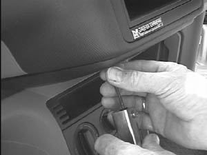 En hand installerar en monteringsbygel i en bil.