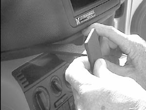 En person installerar en monteringsbygel i en bil.