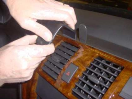 En hand installerar en monteringsbygel på bilens instrumentpanel.