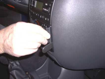 En hand justerar en knapp i bilen, möjligtvis en Ford-modell.