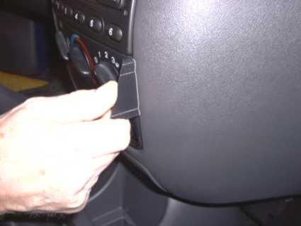 En hand justerar en ratt eller reglage på en bilinteriör.