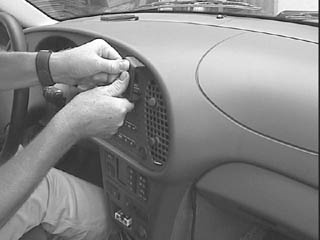 En person installerar en träpanel i en Saab 9-3 från 98-02.