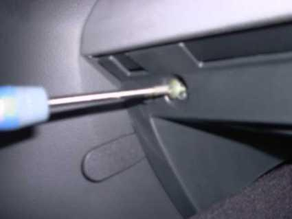 En skruvmejsel som fästs vid en skruv i bilinteriör.