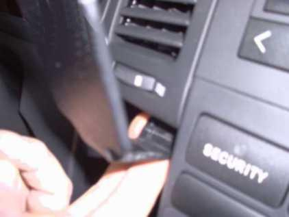 En hand som håller i en del av instrumentpanelen i en Toyota Corolla Verso.