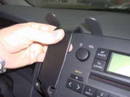 En hand justerar en del av instrumentpanelen i en Toyota Corolla Verso.
