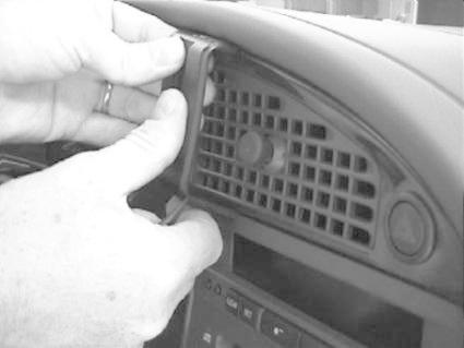 En person installerar en träpanel i Saab 9-5:s mittkonsol.