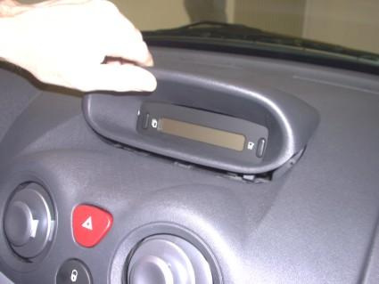 En hand håller i en del av instrumentbrädan i en Citroën C2/C3.