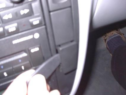 Vinklad del av bilens interiör, möjligtvis en kontroll eller knapp.