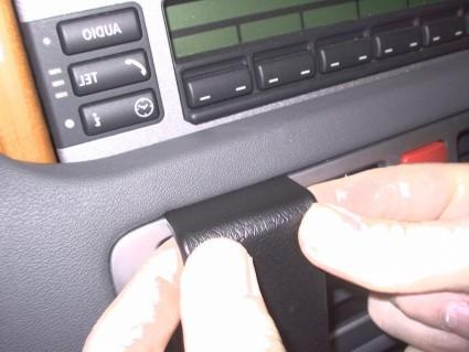 En hand som håller i en svart del av interiören i en Range Rover.