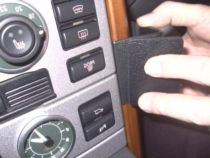 En hand som håller i en svart del av interiören i en Range Rover.