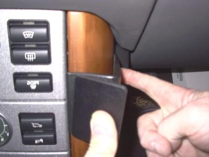 Bild visar en hand som pekar på en del av en bilinteriör.