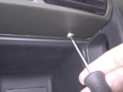 En hand håller en skruvmejsel vid en skruv i interiören av en Honda CR-V 02-06.
