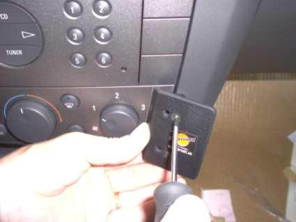 En person installerar en del på en bilradio.