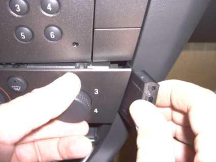 En hand visar en knapp som installeras i instrumentpanelen.