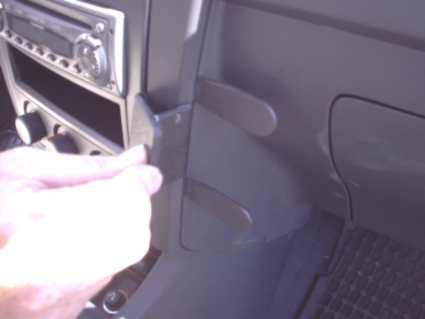 En hand justerar en del av instrumentpanelen i en bil.