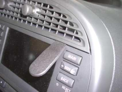 En del av bilens instrumentpanel med knappar och luftutloppsgaller.