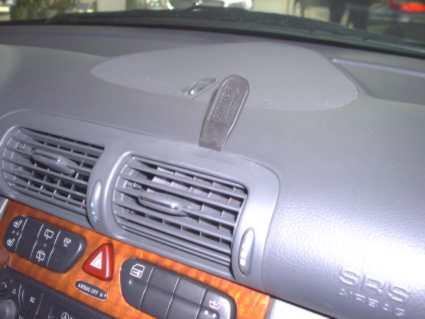 Vinklad högdel av bilinteriör med luftventiler och kontrollpanel.