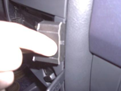 En hand trycker på en knapp i en bilpanel.