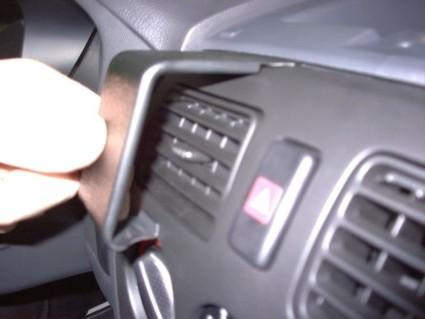 En hand justerar ett luftutlopp i en bilpanel.