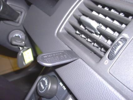 En central ventilationsdel med knapp och fäste för nyckel.