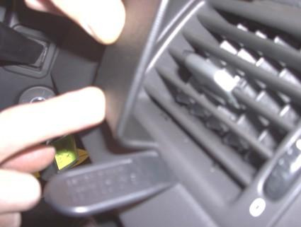 En hand pekar på en del av interiören i en Volvo XC90.