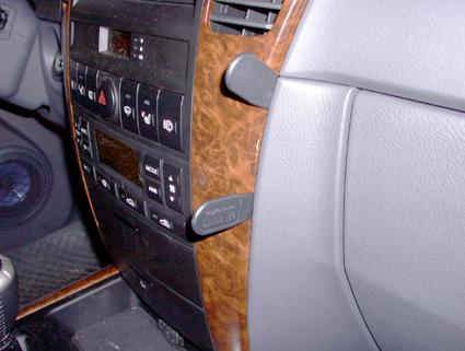 Instrumentpanel med brunt träinlägg och knappar för kontroller.