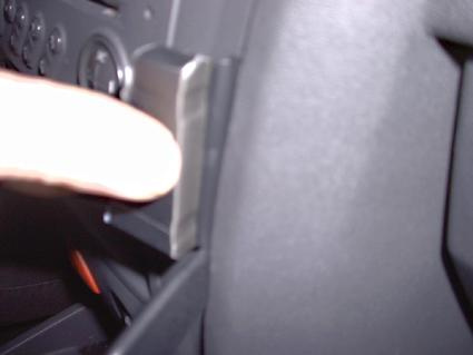 En hand trycker på en knapp eller spak i en bilinteriör.