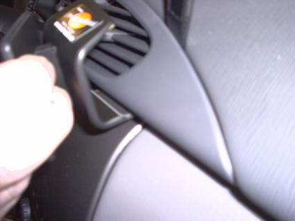 En hand justerar luftventilen i en bilinteriör.