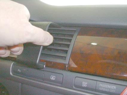 En hand justerar luftventilen i en Audi A8 interiör.