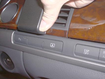 En hand trycker ned en knapp på instrumentbrädan i en Audi A8.