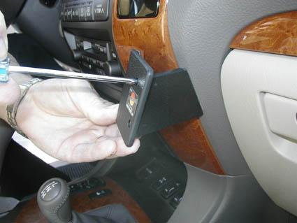 En hand som installerar en monteringsbygel i en bil.