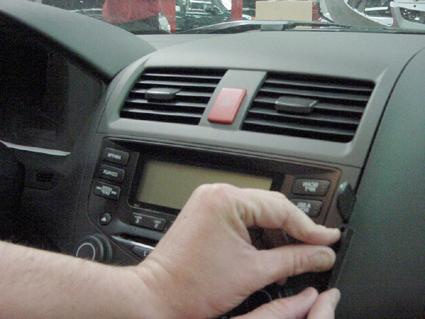 En hand som justerar kontrollpanel i en Honda Accord 03-07.