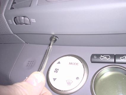 En hand som använder en skruvmejsel på instrumentpanelen i en Nissan Micra.