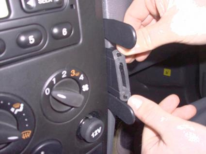 En hand håller en del vid instrumentpanelen i en Ford Transit Connect/Tourneo Connect.