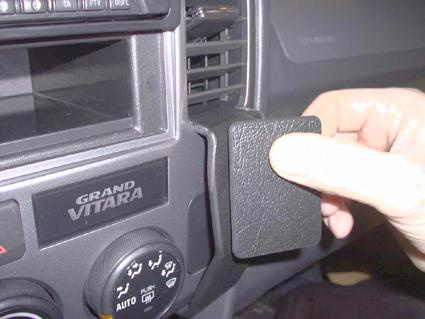 En hand håller en vinklad del för Suzuki Grand Vitara eller XL-7.