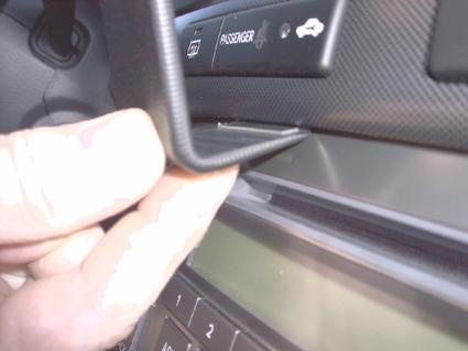 En hand som håller en del av instrumentpanelen i en Toyota Avensis.