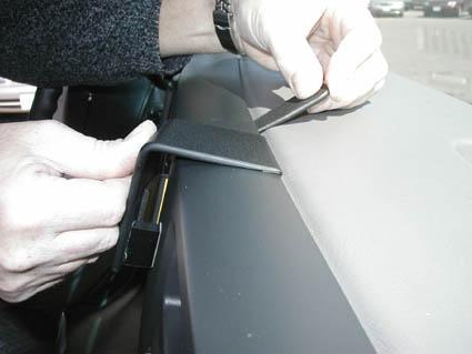 En person installerar en del på instrumentbrädan i en Chevrolet Van.