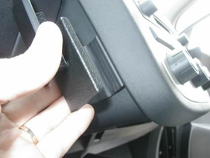 En hand som håller i en svart detalj nära instrumentpanelen i en Nissan Murano.