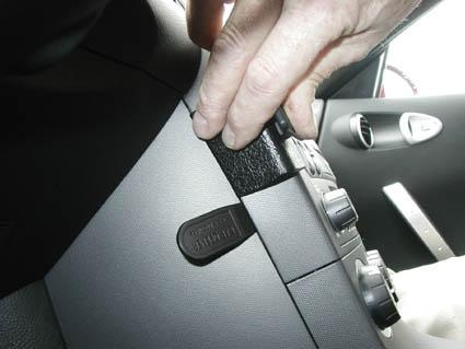 Hand som justerar en monteringsbygel i en bilinteriör.