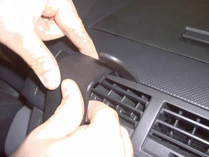 En hand justerar en del av luftventilen i en Mazda 2 från 03-07.