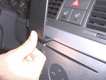 En hand trycker på en panel i en bilinteriör.