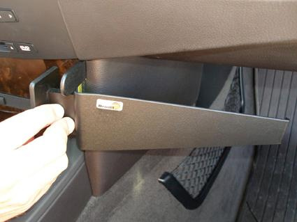 Ett handtag som öppnar en vinklad förvaringslåda i en BMW.