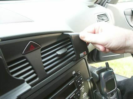 Hand som justerar en del av instrumentbrädan i en Volvo V70.