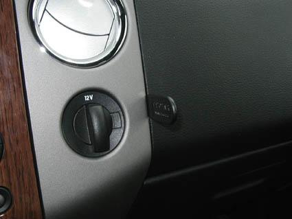 Ett närbild av Ford F-150 04-08s instrumentpanel med 12V-uttag.