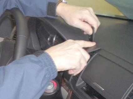 En person arbetar med instrumentpanelen i en Subaru Outback/Legacy 04-09.